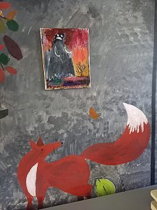 Jäsen toteuttamia maalauksia Pönkän klubitalon seinällä: ihmishahmo pikku maalauksessa ja seinän alareunassa kettu.